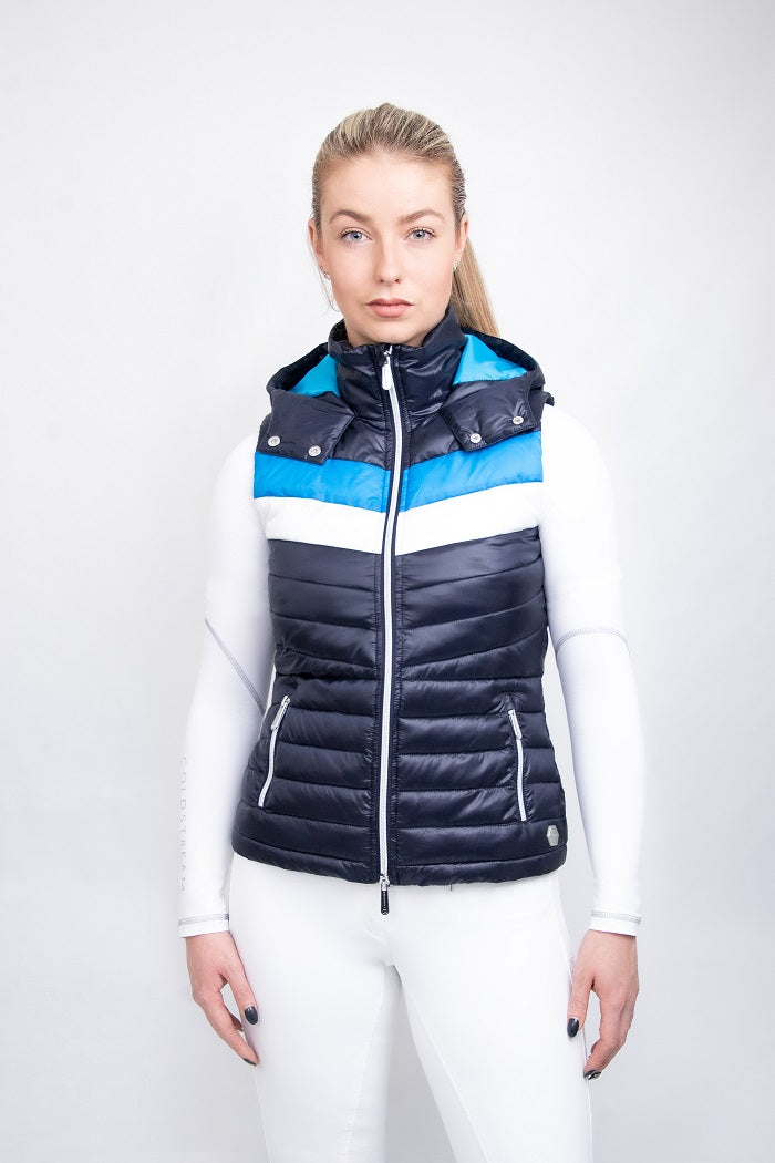 Woman wearing a navy, blue and white gilet and white breeches on a white background