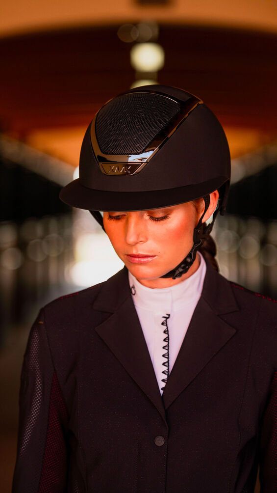 Woman wearing a horse riding helmet on a blurred background
