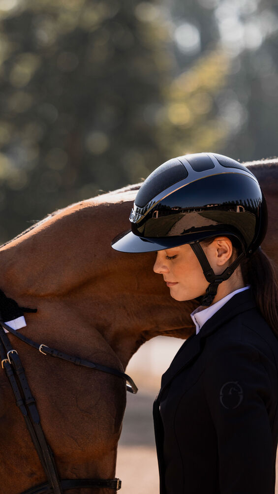 Woman holding a horse with a blurred background