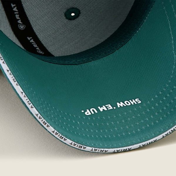 Teal cap with 'Ariat' branding and text on a beige background