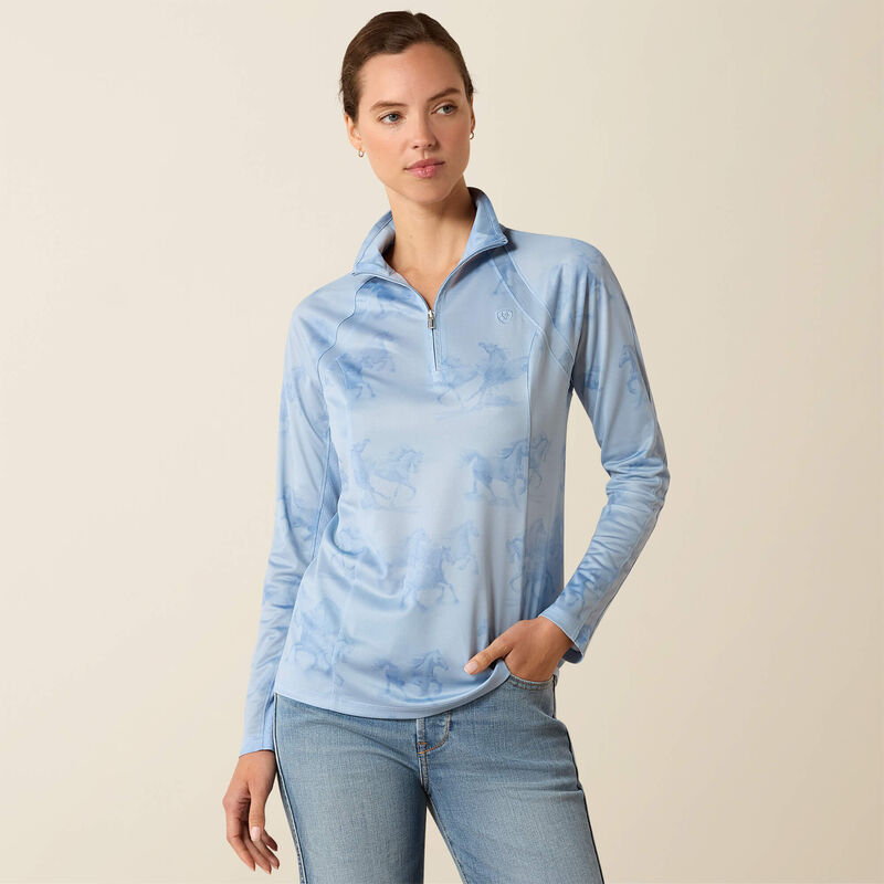 Woman wearing a light blue pullover with a subtle pattern on a beige background