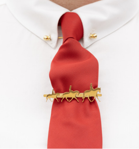 Red tie with a gold horse-shaped tie clip on a white shirt background