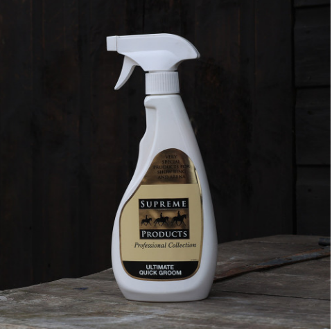 Supreme Products Ultimate Quick Groom spray bottle on a wooden surface with a dark background