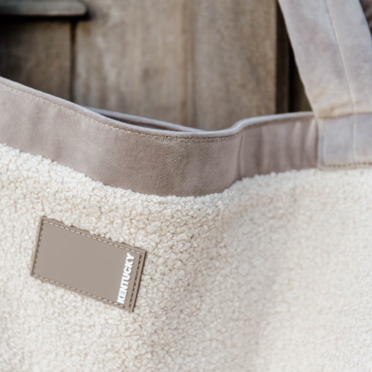 Close-up of a beige tote bag with a textured surface and a visible 'Kentucky' label.