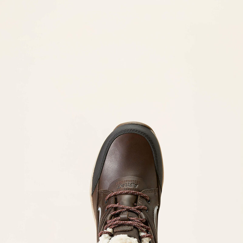Brown leather boot with white laces on a beige background