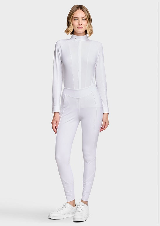 A woman modeling a white long-sleeve athletic jumpsuit with a mock neck and front zipper, paired with white sneakers, against a light gray studio background.