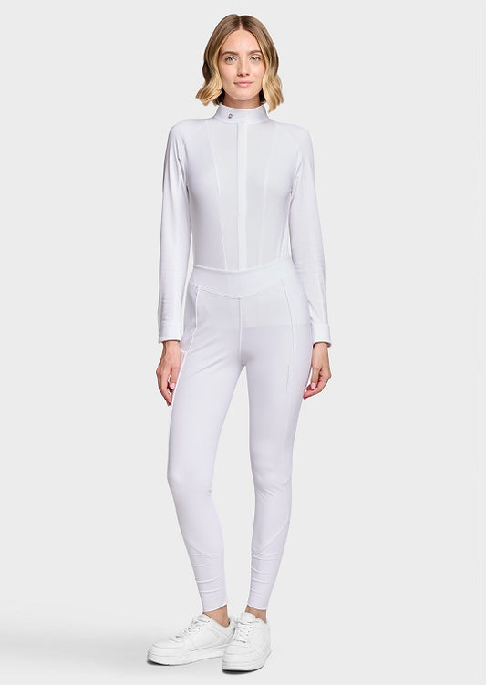 A woman modeling a white long-sleeve athletic jumpsuit with a mock neck and front zipper, paired with white sneakers, against a light gray studio background.