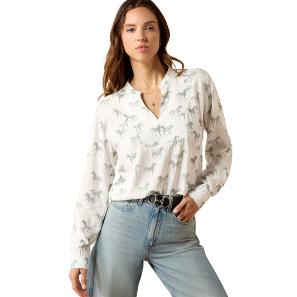 Woman wearing a white blouse with horse pattern and blue jeans on a white background