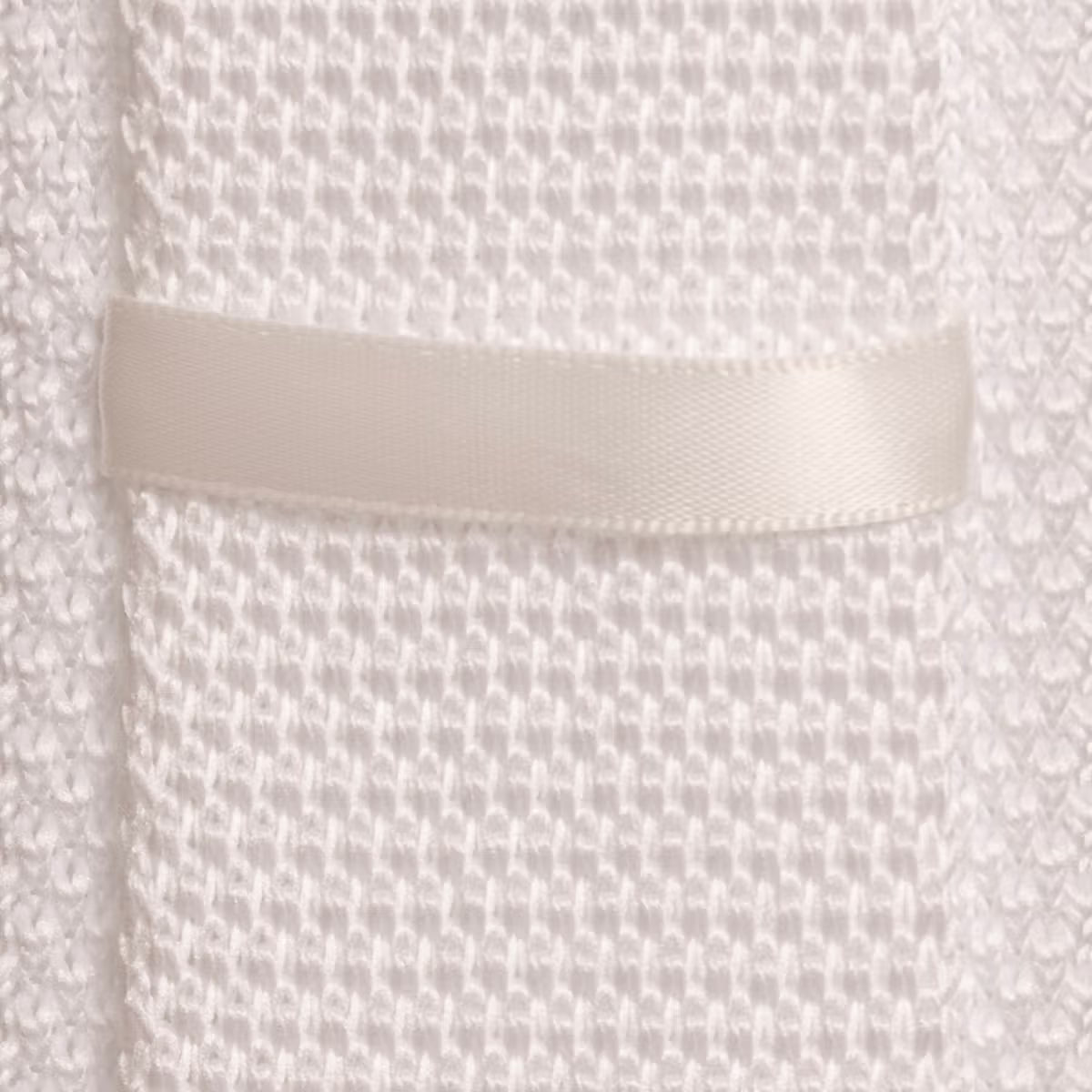 Close-up of a textured fabric with a pocket detail on a white background
