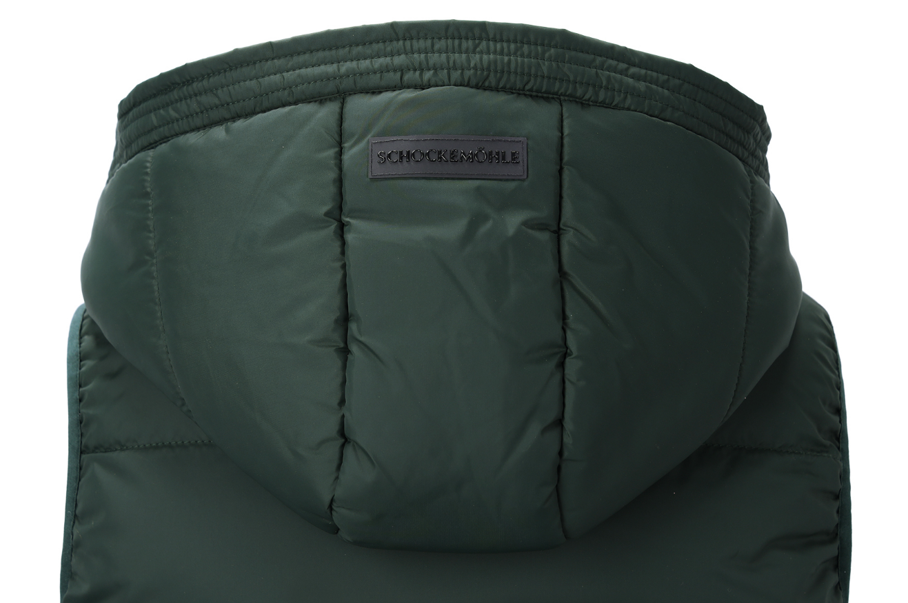 Close-up of the hood of a dark forest green puffer jacket, showing the quilted stitching and a small dark brand label that reads 'SCHOCKEMOHLE'.