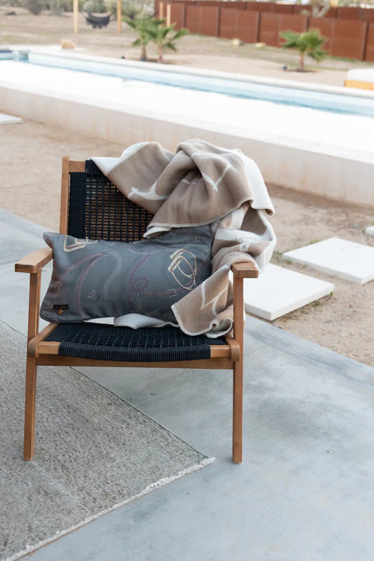 Green cushion with horse tack elements on a chair in an outdoor setting