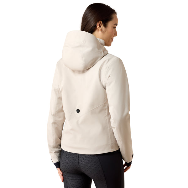A woman shown from the back wearing a light cream hooded jacket and dark patterned leggings against a plain white background.