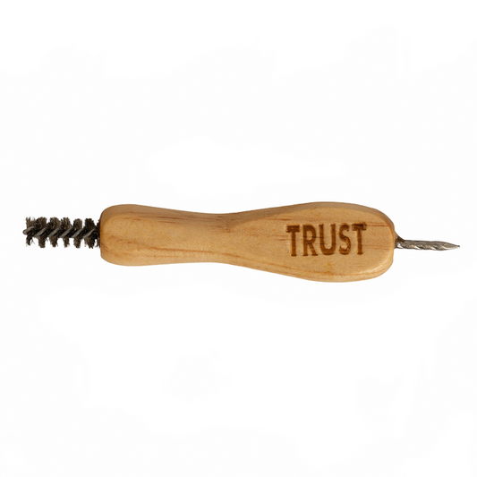 A wooden hand tool with a brushed metal wire brush on one end and a small metal pointed tip on the other, engraved with the word 'TRUST' on a plain white background.