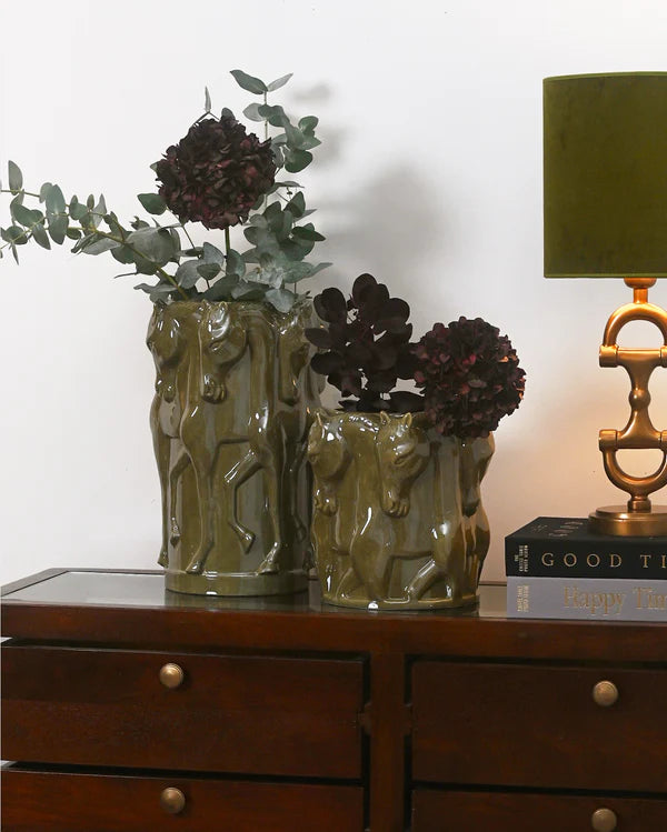 Two green horse themed vases with flowers in them in a home setting