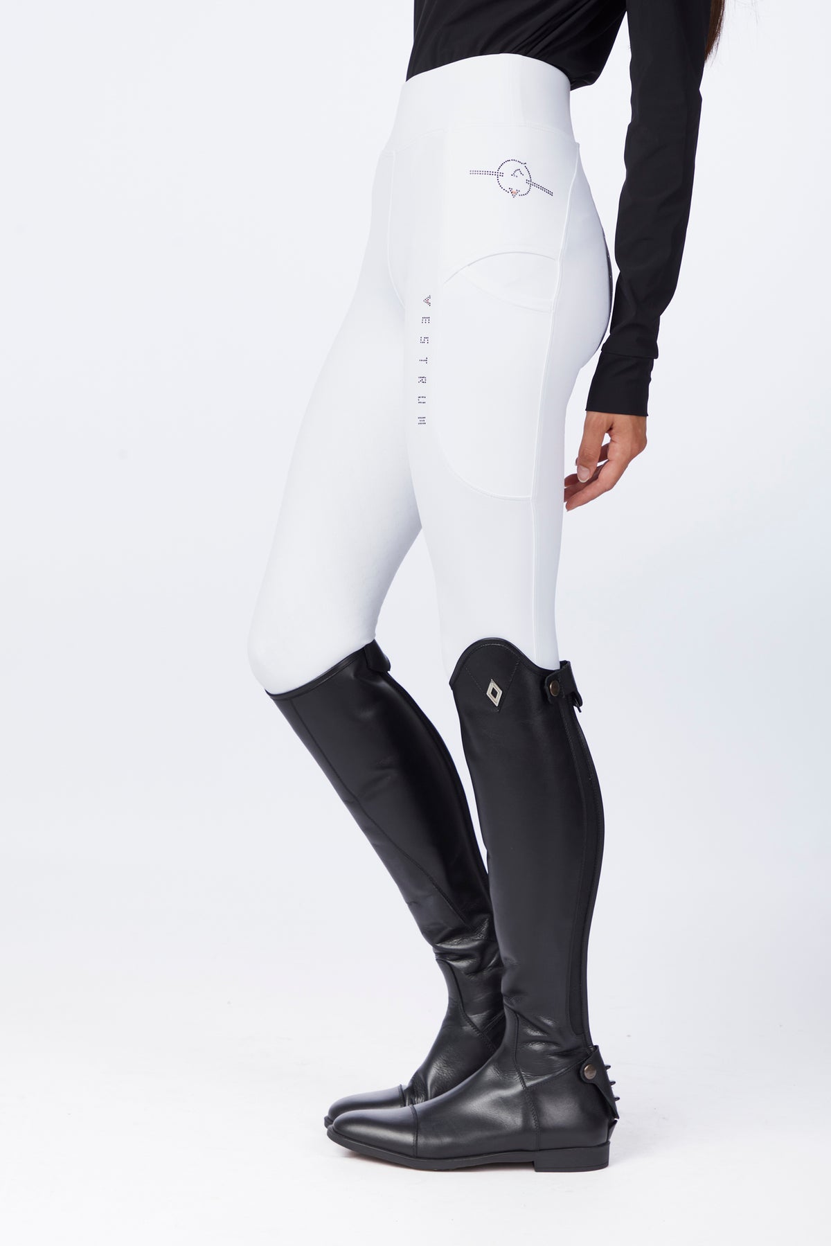 White equestrian riding tights worn by a model, paired with black riding boots, shown from the waist down against a clean white studio background.