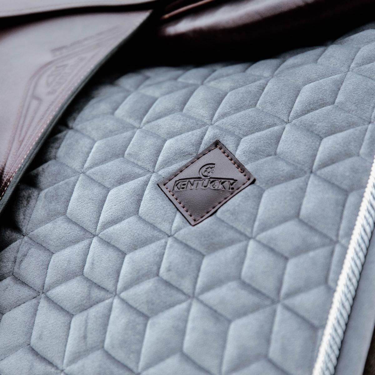 Quilted gray saddle pad with a 'Kentucky' logo on a dark background
