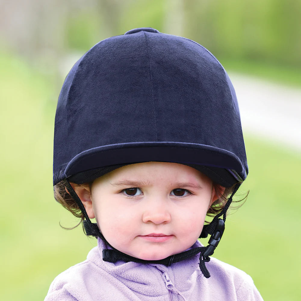 Child wearing a navy helmet with a blurred green background