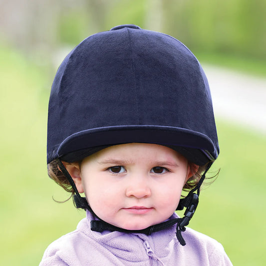 Child wearing a navy helmet with a blurred green background
