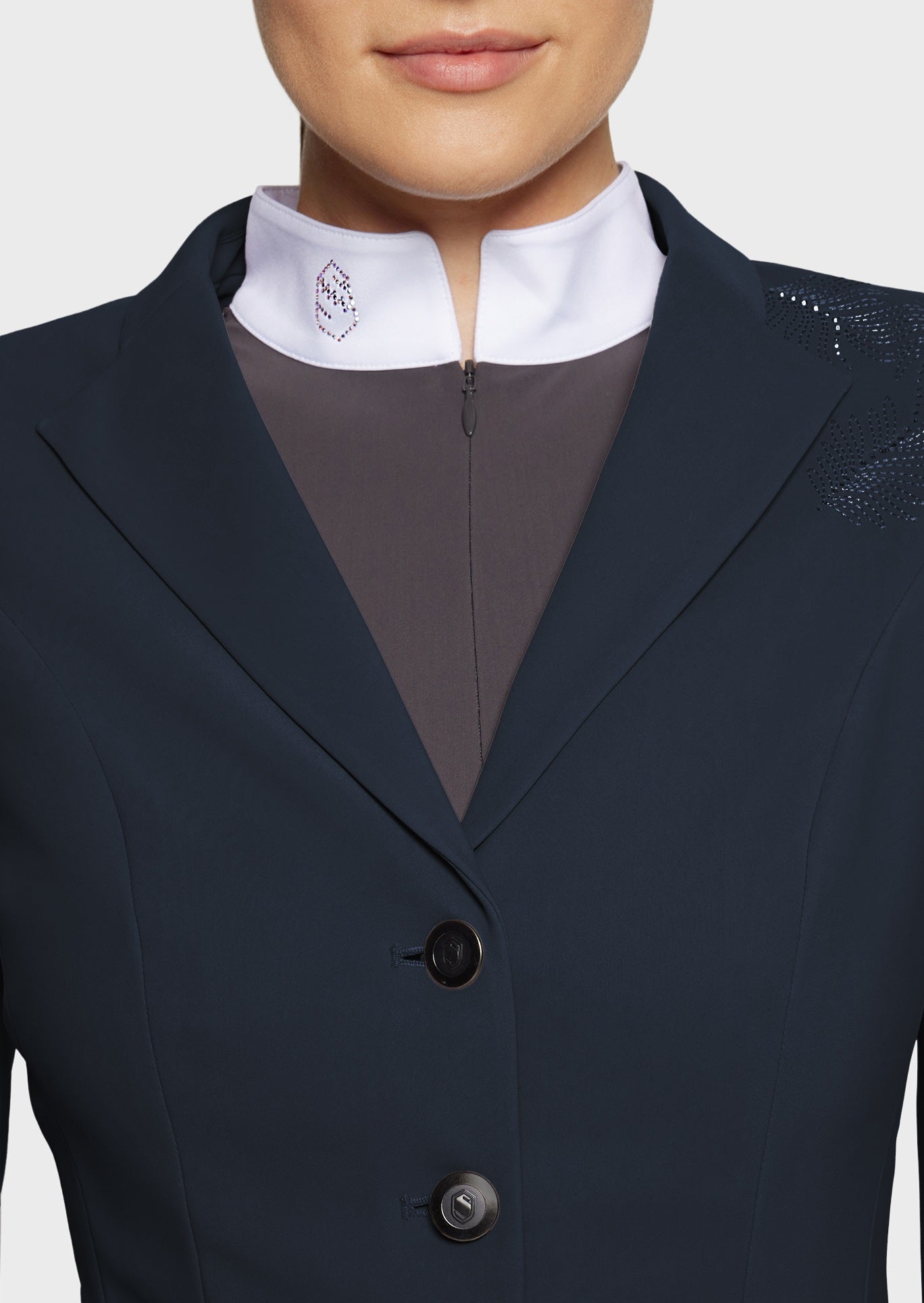 Navy blazer with a white shirt and brown vest on a plain background