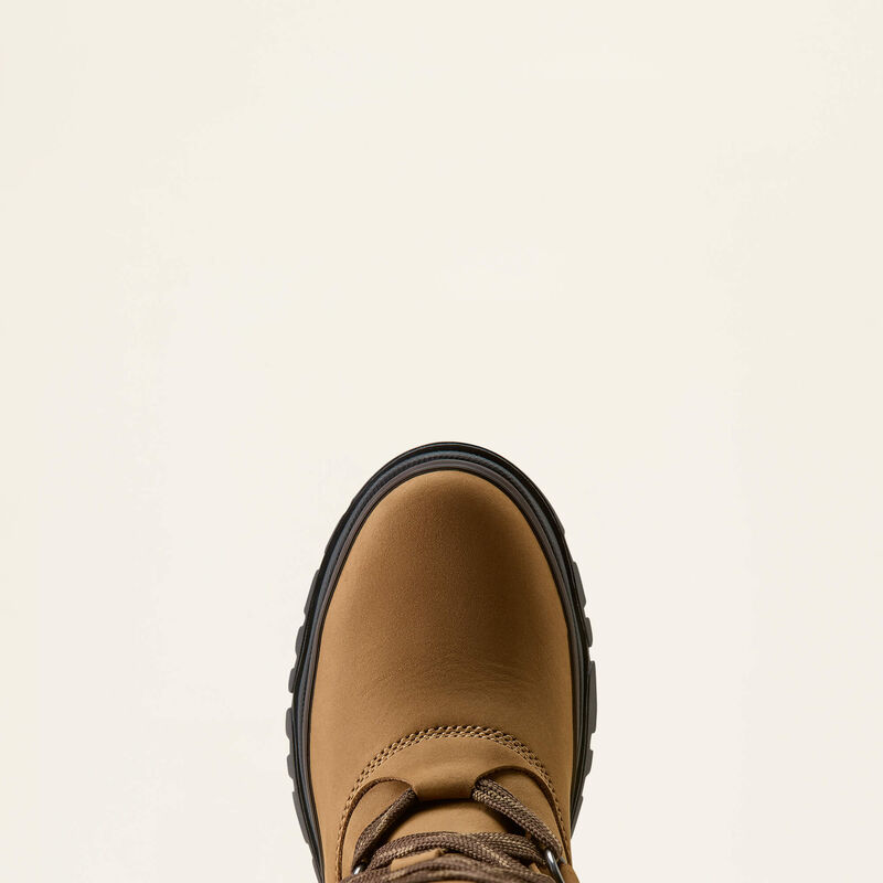 A close-up top-down view of a tan leather boot with a black sole, centered against a solid off-white background.