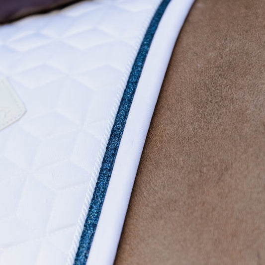 Detail of a white saddle pad with a glitter navy band