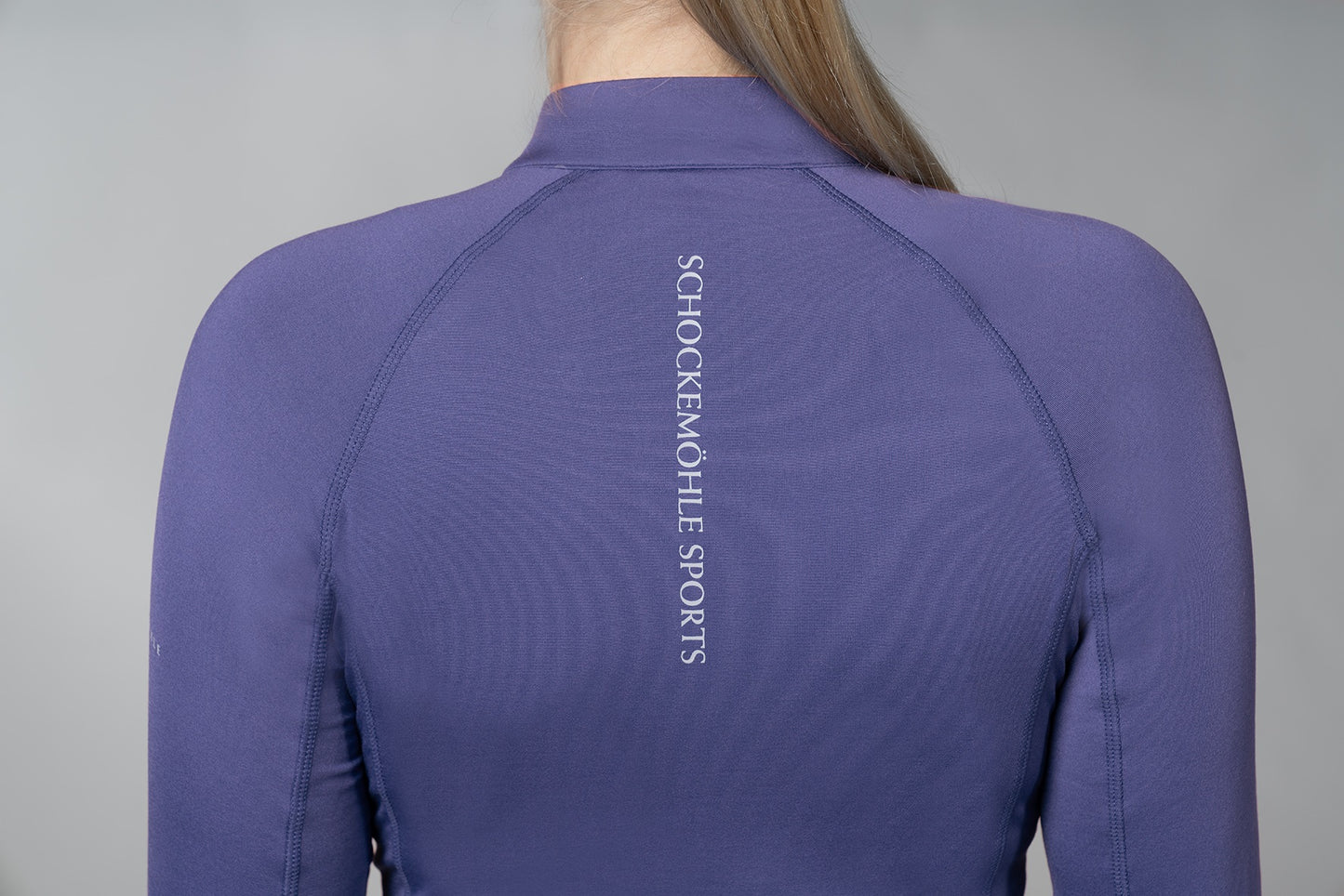 Back of blue baselayer with Schockemohle Sports writing on a white background