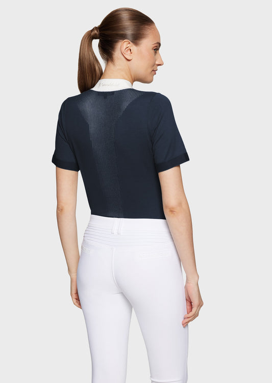 Woman wearing a navy jumper and white breeches on a white background