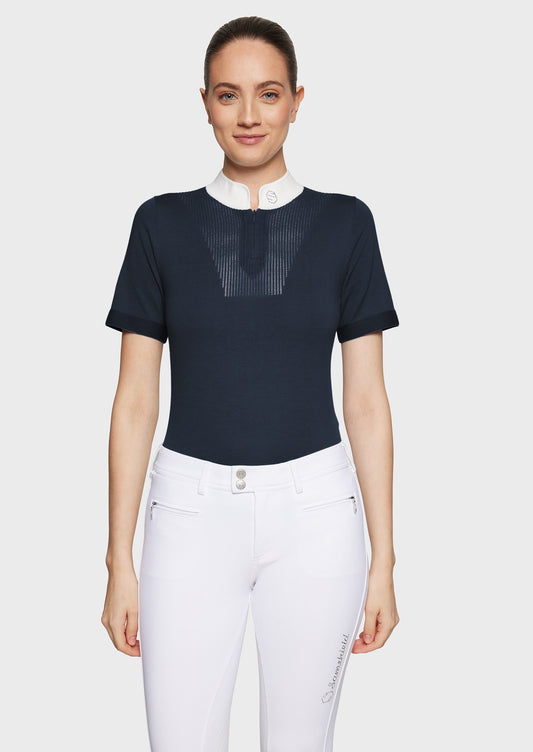 Woman wearing a navy jumper and white breeches on a white background